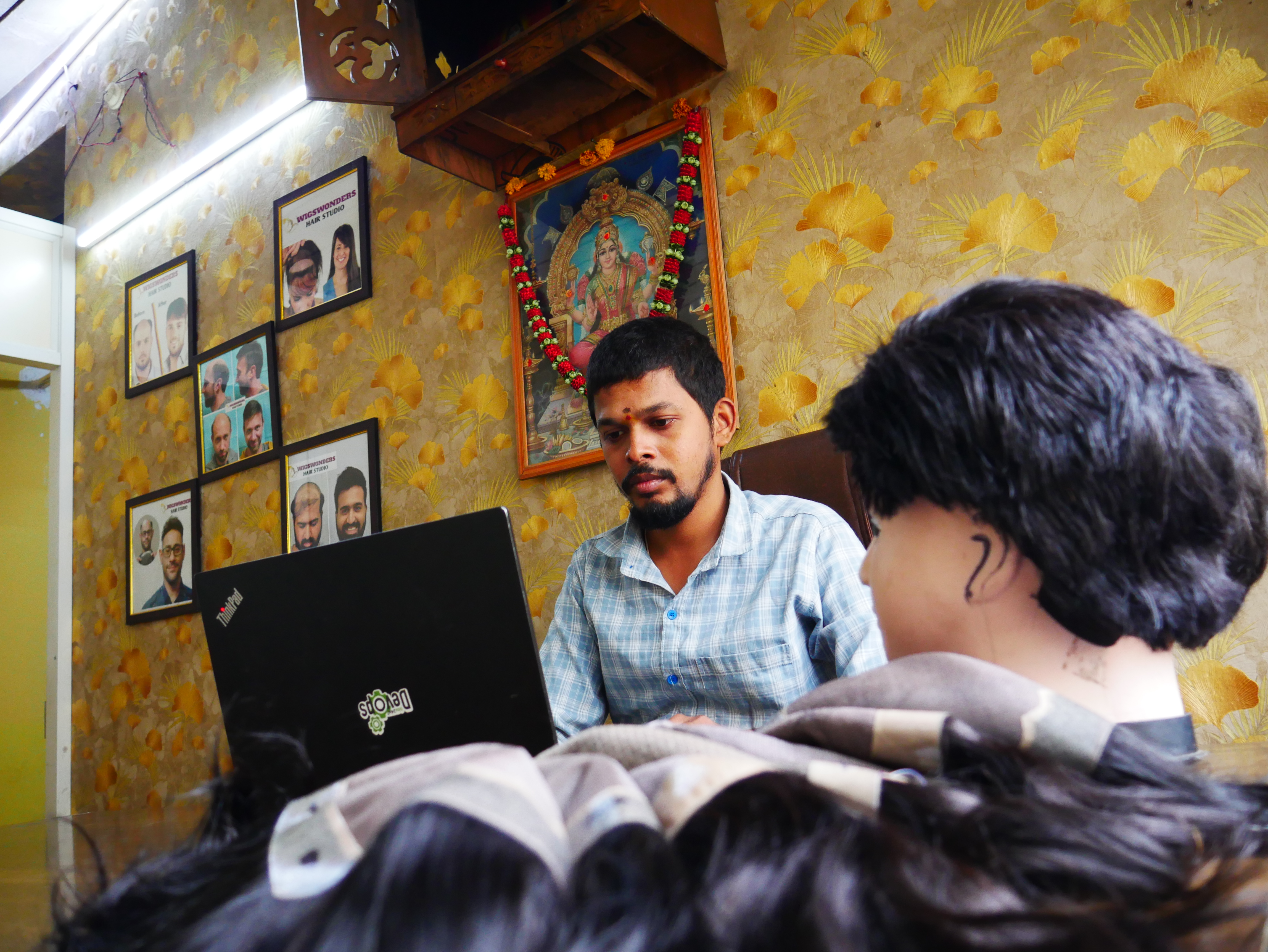 Naresh, founder of Wig Wonders Hair Studio, holding a hand-crafted hair patch